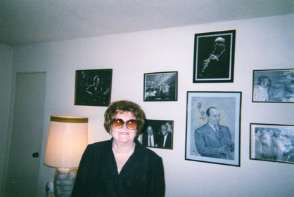 With a large potrait of Barney over her head, to the right